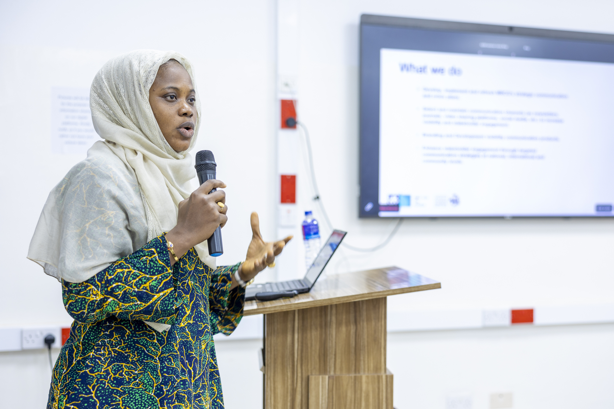 Woman speaking at the front of a conference room